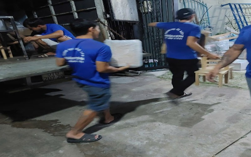 Nhân viên cẩn thận vận chuyển đồ đạc đã bọc lót lên xe tải chặng đường dài